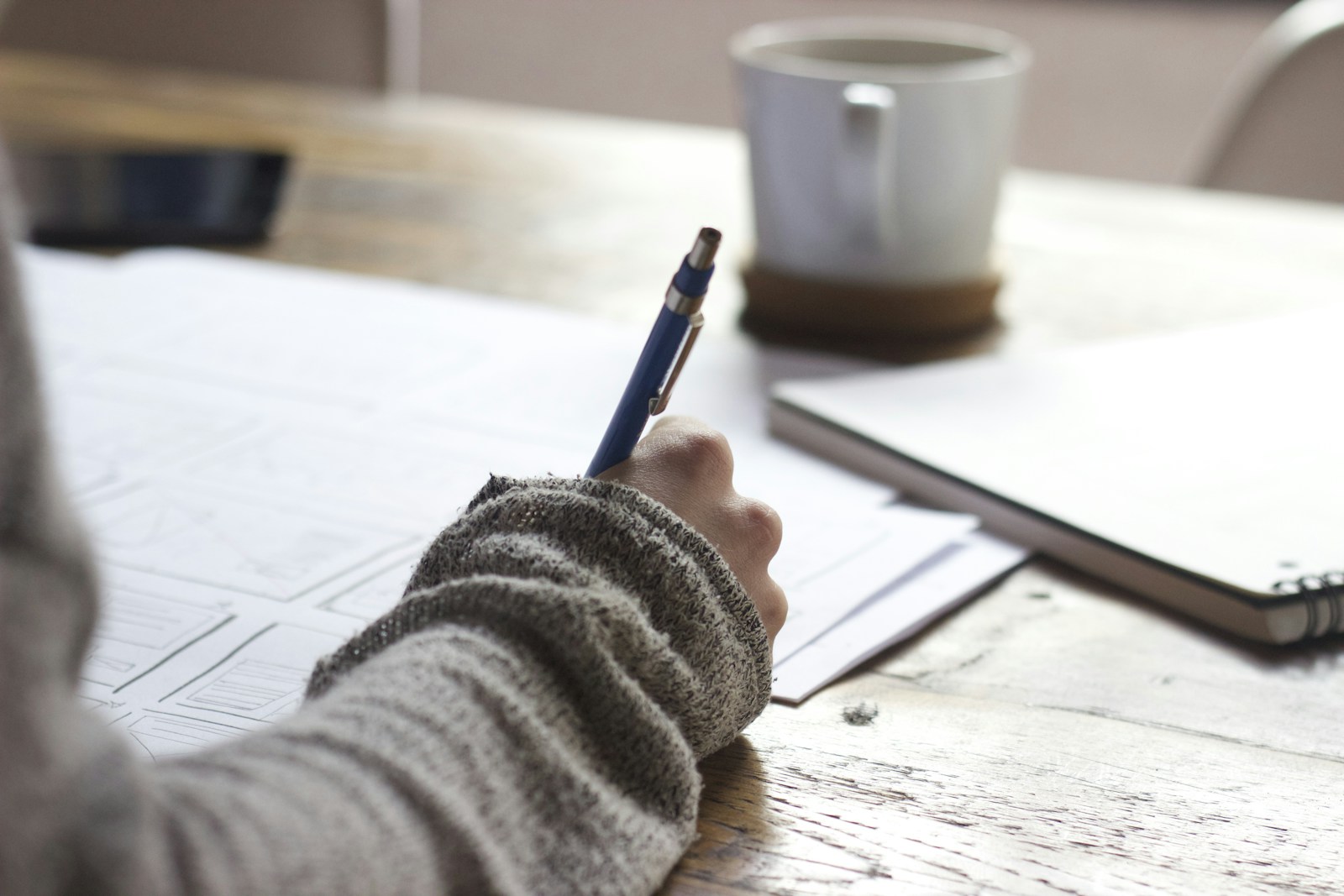 An editor reviewing handwritten notes at a desk